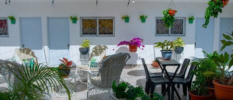 A patio area with outdoor seating, potted plants, and hanging umbrellas.
