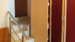 A staircase with a metal handrail leading to a landing. A wooden chair is placed on the left side of the stairs. - 1 Bed Flat - Sleeps 2 - Parking - Wifi (Novalja)