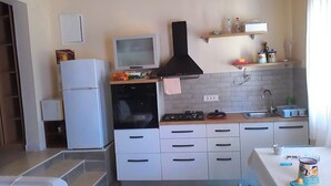 A compact kitchen with a refrigerator, stove, microwave, and a small sink. - 1 Bed Flat - Sleeps 2 - Parking - Wifi (Novalja)