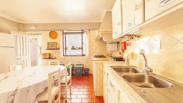 Cocina compacta con comedor, ventana y salpicadero de azulejos.