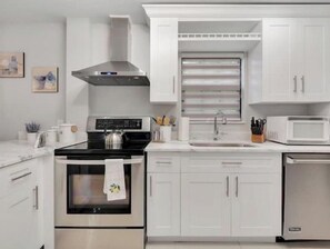 Enjoy cooking in this well-equipped kitchen with a stove, microwave, and sink.