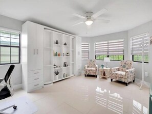 Relax in this serene room with a high ceiling, ceiling fan, and large wardrobe, perfect for storing your belongings.