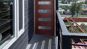 A modern building with a wooden door and large windows. - SHEUEN PATAGONIA (Natales)