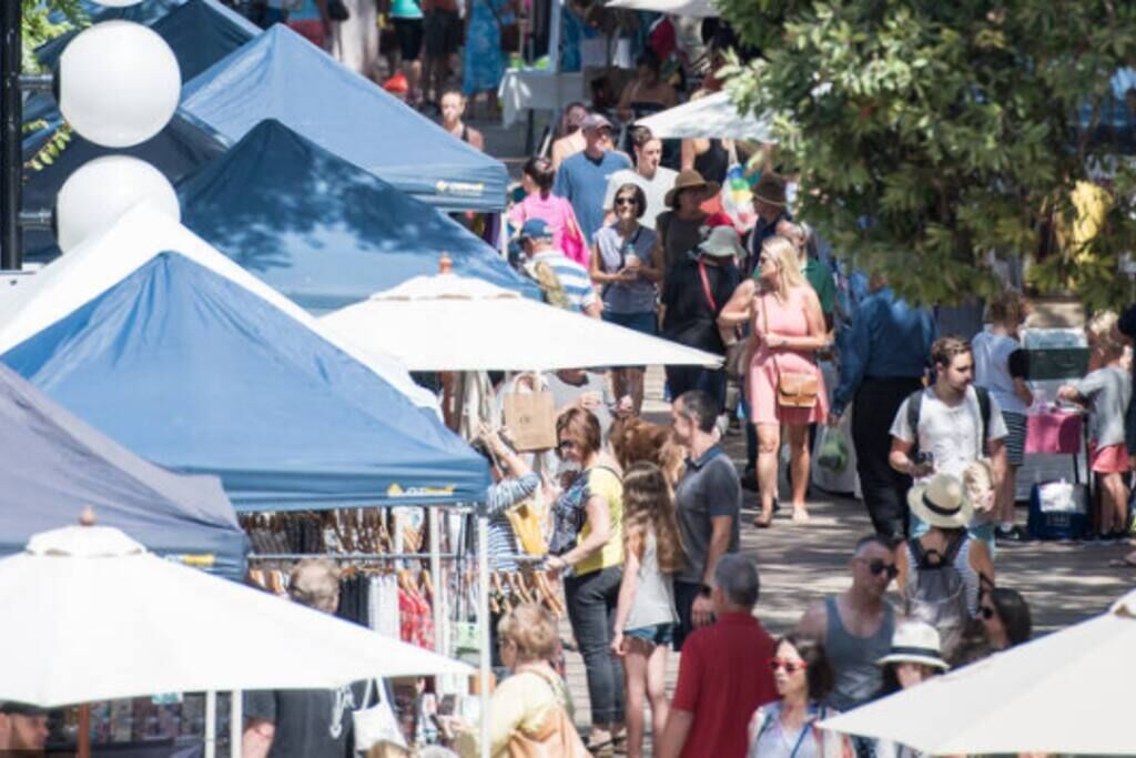 A crowded outdoor market with tents and people.