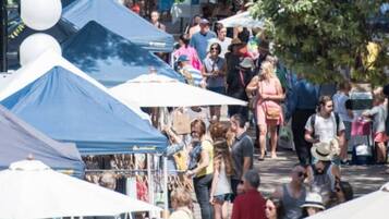 A crowded outdoor market with tents and people.