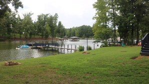 Vista sul lago con un pontile, barche e un gazebo.