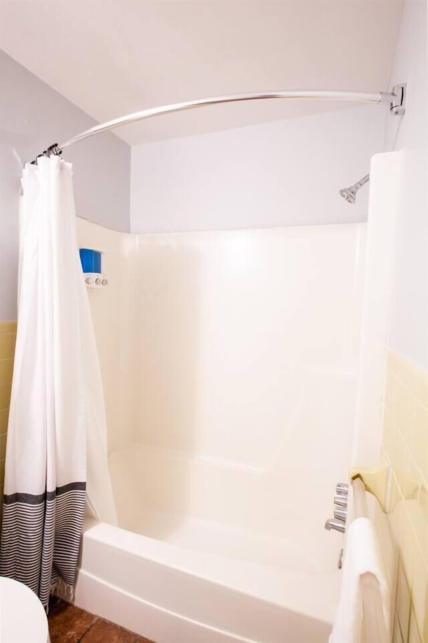 Une salle de bain avec une baignoire, un rideau de douche et un porte-serviettes.
