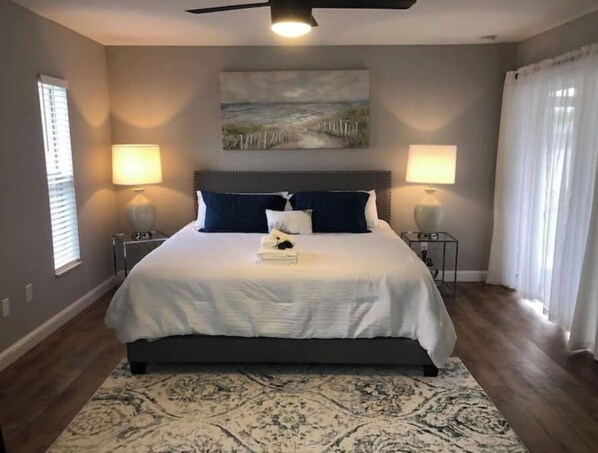 Cozy retreat with a large bed, bedside tables, and a decorative painting above.