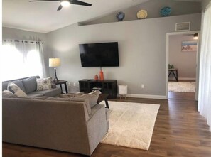 Relax in this stylish living room with a sofa, flat-screen TV, and decorative vase.