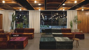 Un lobby espacioso con diseño moderno, que ofrece una variedad de opciones de asientos y grandes ventanales con vistas al exterior.