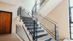 Eine Treppe mit schwarzen Geländern und Marmorstufen, die zu einer oberen Etage führt.