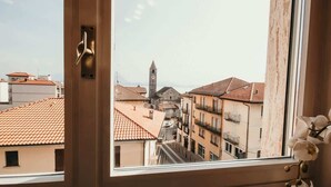 Ein Fenster mit Blick auf eine Stadt, einschließlich Gebäude und eines Turms.