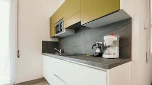 Una cocina moderna con microondas integrado, cafetera y una encimera elegante.