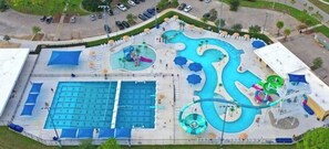 Relax by the large rectangular pool with multiple lanes, surrounded by lounge chairs and umbrellas.