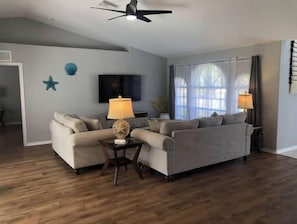 Relax in this stylish living room with a sofa, flat-screen TV, and cozy reading nook.