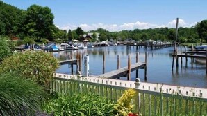A marina with boats docked, surrounded by greenery and a clear sky. - Northside Cottage. Close to community pool & beaches! Sleeps 12. Fast Wi-Fi! (South Haven)