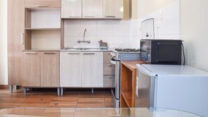 A modern kitchen with light wood cabinets, a stainless steel sink, and a built-in oven. - Pikaflor Cerezo mini apartment (Cusco)