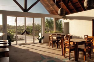 A spacious patio with a dining table and chairs, large sliding glass doors, and a view of the outdoors.