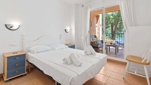 A hotel room with a bed, bedside tables, a chair, and a view of the outdoors.