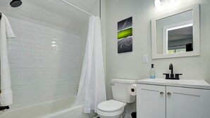 Un baño moderno con bañera, inodoro y tocador.