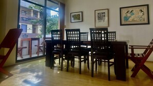 A dining area with a large window, wooden chairs, and a table. - HOTEL CASA TERESA GALERIA CAFE  (Juchitan de Zaragoza)