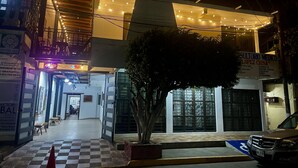 A building with a checkered floor, a tree in the center, and a parked car. - HOTEL CASA TERESA GALERIA CAFE  (Juchitan de Zaragoza)