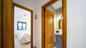 A hotel room with a bed, a bathroom with a mirror, and a window with a view. - El Refugio de El Espilo in Almería (Andalusia) (Lúcar)