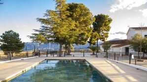 A rectangular pool with clear water, surrounded by a tiled deck and a metal railing. - El Refugio de El Espilo in Almería (Andalusia) (Lúcar)