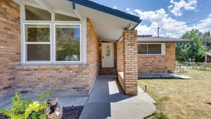 A two-story brick house with a front porch, a garage, and a small backyard. - Grand Junction Vacation Rental w/ Patio & Grill! (Grand Junction)