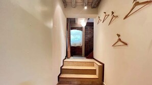 A staircase leading to a bedroom with a bed and a window.