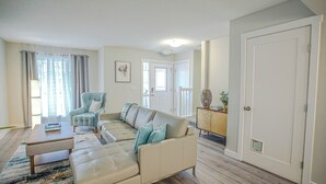 A living room with a sectional sofa, a coffee table, and a side table with a lamp. - Peace Fort (Fort Saskatchewan)