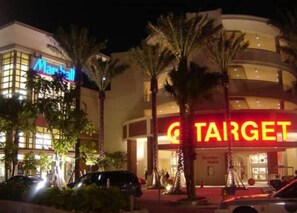 A Target store with a large illuminated sign, surrounded by palm trees and a parking lot.