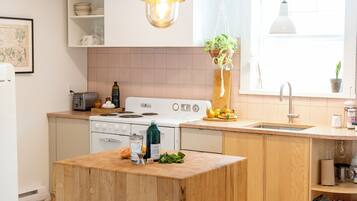 A modern kitchen with wooden cabinets, a central island, and pendant lighting.