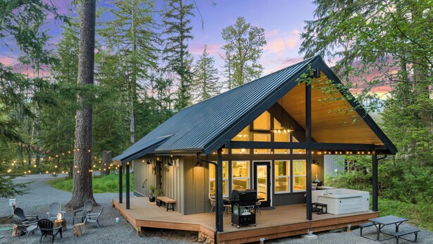 Une cabane dotée d’une terrasse, d’un espace salon extérieur et d’un coin barbecue.