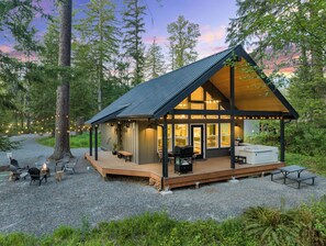 A cabin with a deck, outdoor seating, and a grill area. - Cozy cabin retreat w/hot tub less than 5 mi to Mt Rainier NP (Ashford)