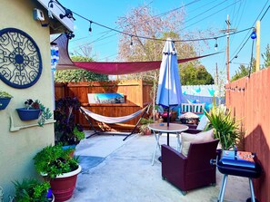 A backyard with a hammock, outdoor furniture, and potted plants. - Hidden Gem Los Angeles: 2bd house with dreamy backyard (Los Angeles)