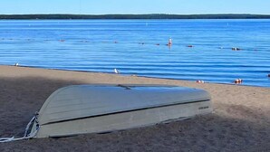 A beach with a tent and calm water. - The Blueberry House - Spacious, Family & Pet-Friendly Retreat near Sebago Lake (Sebago)