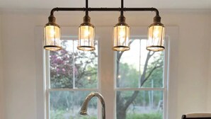 A kitchen with a stainless steel sink, a modern faucet, and a pendant light fixture with three bulbs. - The Blueberry House - Spacious, Family & Pet-Friendly Retreat near Sebago Lake (Sebago)