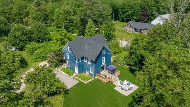 A large blue house with a deck, surrounded by lush greenery. - The Blueberry House - Spacious, Family & Pet-Friendly Retreat near Sebago Lake (Sebago)
