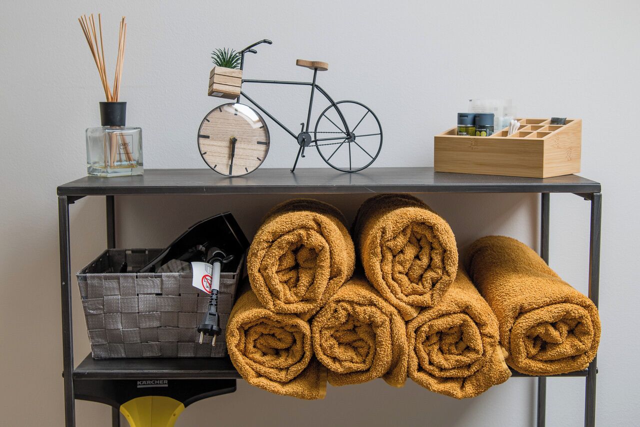 A shelf with a bicycle, a clock, a plant, and a wooden box.