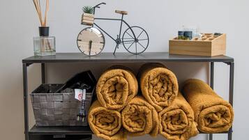 A shelf with a bicycle, a clock, a plant, and a wooden box.