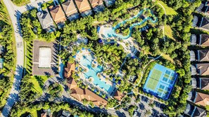 An aerial view of a resort with a swimming pool, tennis court, and landscaped areas. - Sunshine at Solterra (Davenport)