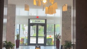 Un vestíbulo moderno con mostrador de recepción, zona de estar y un cartel que dice "OOAI".
