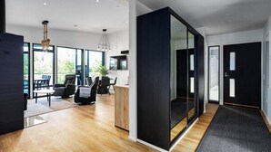 A modern interior with a dining area, seating, and a kitchen. - Villa Syreeni - Seafront/Jacuzzi (Porvoo)