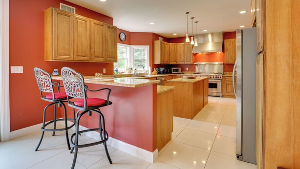 A modern kitchen with wooden cabinets, a central island, and bar stools. - Glen Spey Home w/ Grill ~ 5 Mi to Delaware River (Glen Spey)