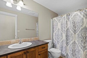 A bathroom with a sink, mirror, and toilet.