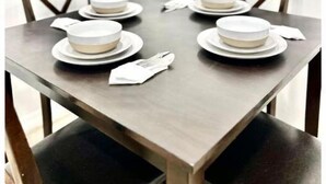 A dining table set with plates, bowls, and cutlery, surrounded by chairs. - “NEW” Traveler’s Getaway (Pinellas Park)