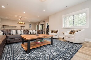 Una sala de estar moderna con un sofá modular, una mesa de centro de madera y una alfombra estampada.