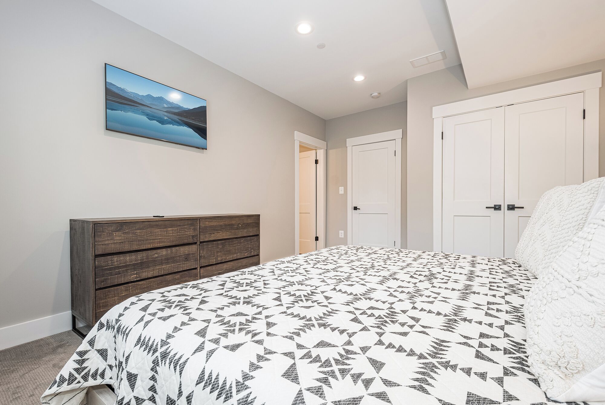 Een slaapkamer met een bed, een kast en een deur.