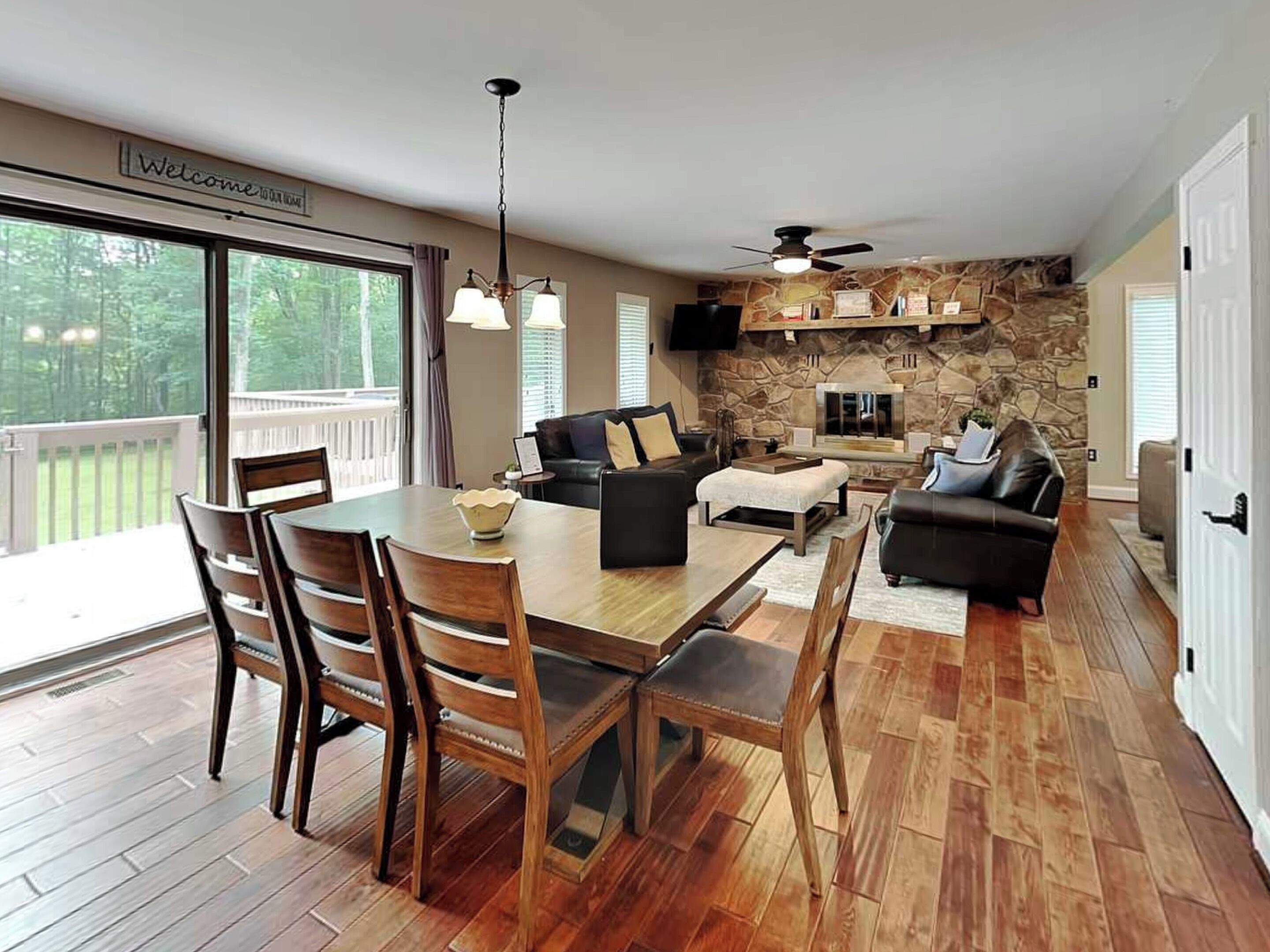 A spacious living area with a dining table, chairs, a sofa, and a fireplace.